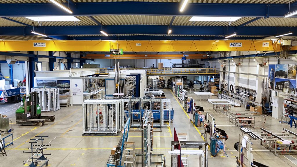 Ansicht der Metallbauhalle von innen mit Arbeitsplätzen und Kranbahn