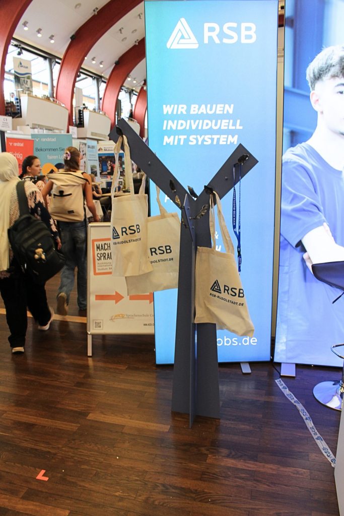 Stahlbaum mit Blätter-Haken woran Messebeutel hängen