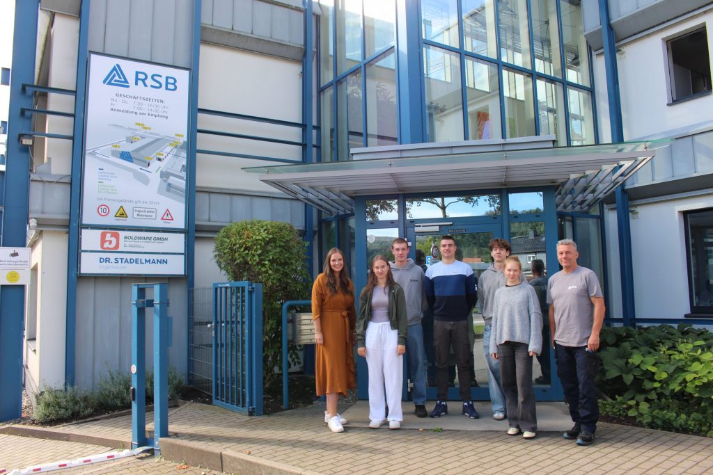 5 neue Auszubildene und ihre 2 Ausbilder stehen vor dem Eingang der RSB