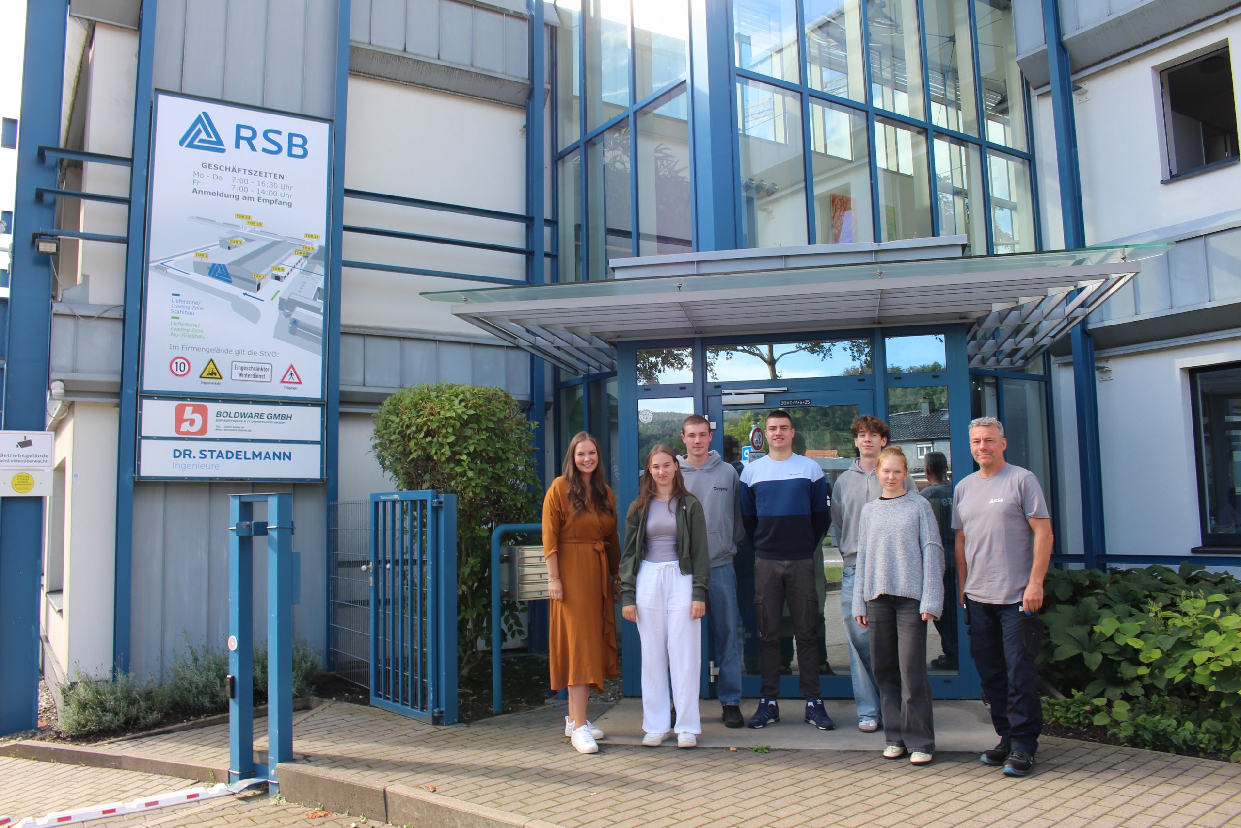 5 neue Auszubildene und ihre 2 Ausbilder stehen vor dem Eingang der RSB